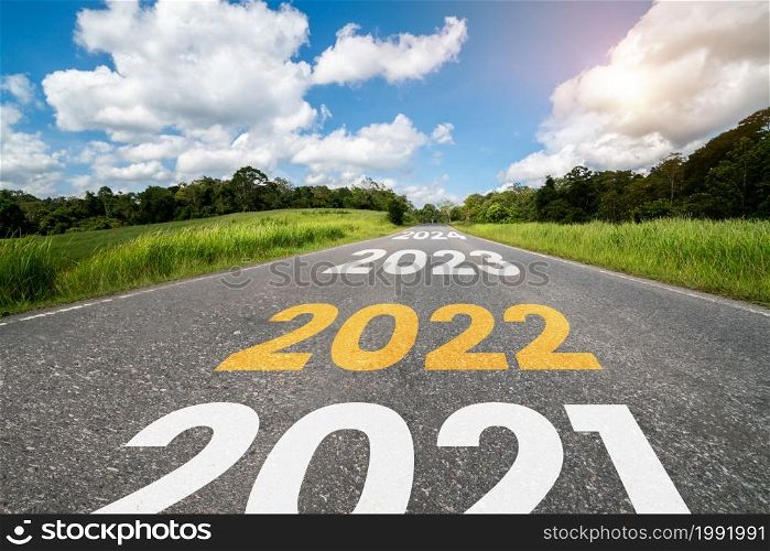 2022 New Year road trip travel and future vision concept . Nature landscape with highway road leading forward to happy new year celebration in the beginning of 2022 for fresh and successful start .. 2022 New Year road trip travel and future vision concept