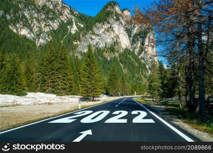 2022 New Year road trip travel and future vision concept . Nature landscape with highway road leading forward to happy new year celebration in the beginning of 2022 for fresh and successful start .