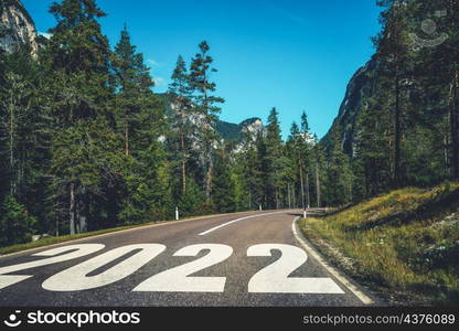 2022 New Year road trip travel and future vision concept . Nature landscape with highway road leading forward to happy new year celebration in the beginning of 2022 for fresh and successful start .