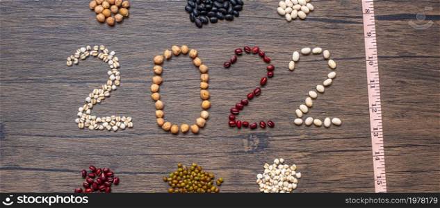 2022 New Year with organic Beans; red, black, white, green, chickpeas and Adlay on table. Goals, Healthy, Motivation, Resolution, Weight loss, dieting and world food day concept