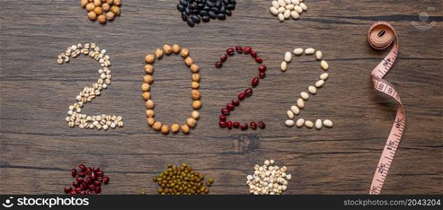 2022 New Year with organic Beans; red, black, white, green, chickpeas and Adlay on table. Goals, Healthy, Motivation, Resolution, Weight loss, dieting and world food day concept