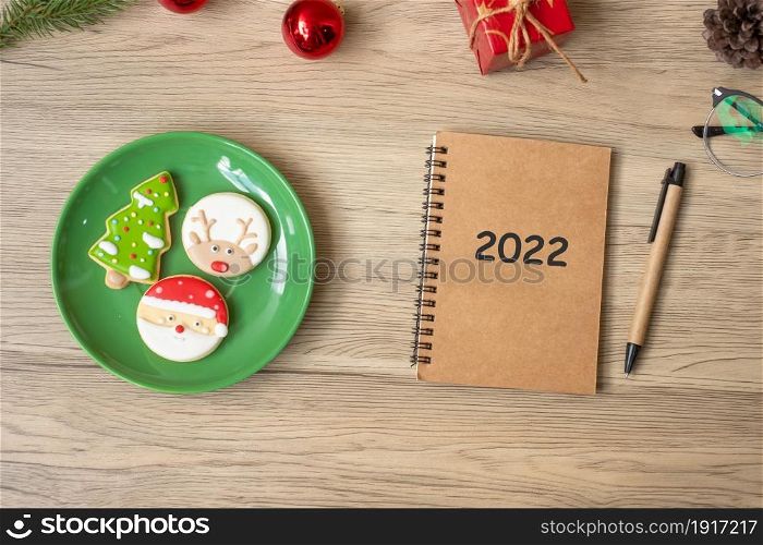 2022 notebook, black, Christmas cookies and pen on wood table, Top view and copy space. Xmas, Happy New Year, Goals, Resolution, To do list, Strategy and Plan concept