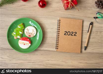 2022 notebook, black, Christmas cookies and pen on wood table, Top view and copy space. Xmas, Happy New Year, Goals, Resolution, To do list, Strategy and Plan concept