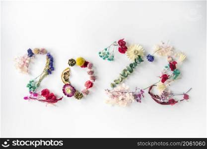 2022 number made from colorful fresh spring plants, flowers and leaves. Happy New Year concept isolated on white background. 2022 creative background, card design top view. 2022 number made from colorful fresh spring plants, flowers and leaves. Happy New Year concept isolated on white background. 2022 creative background, card design
