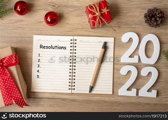 2022 Resolutions with notebook, Christmas gift and pen on wood table. Xmas, Happy New Year, Goals, To do list, start, Strategy and Plan concept