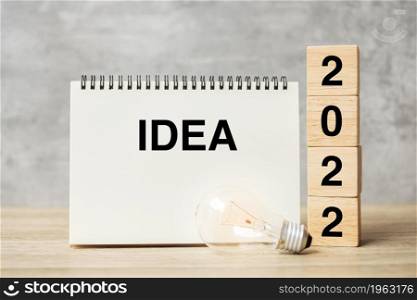 2022 text wood cube blocks and IDEAS word with lightbulb on table. New Year New Ideas, Creative, Innovation, Imagination, inspiration, Resolution, Strategy and goal concept