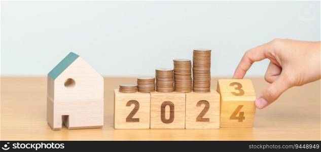 2023 flipping to 2024 year block with house model and Coins stack. real estate, Home loan, tax, investment, mortgage, financial, savings and New Year Resolution concepts