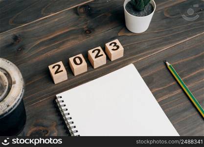 2023 for goals text on notepad blank with coffee cup and pen on wooden desk
