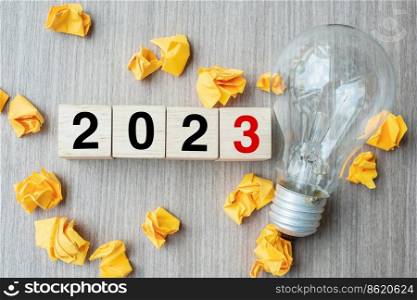 2023 text wood cube blocks and crumbled paper with lightbulb on wooden table background. New Year New Ideas, Creative, Innovation, Imagination, inspiration, Resolution, Strategy and goal concept