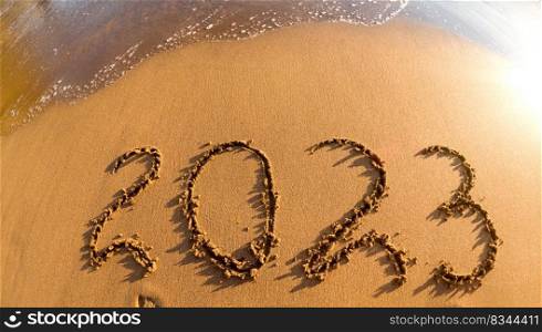 2023 written in sand New Year on the beach