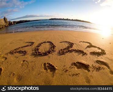 2023 written in sand New Year on the beach