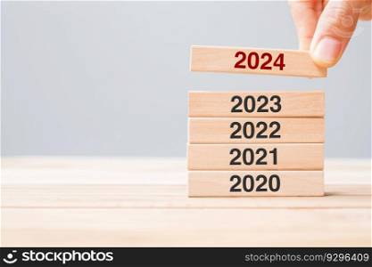 2024 block over 2023 and 2022 wooden building on table background. Business planning, Risk Management, Resolution, strategy, solution, goal, New Year New You and happy holiday concepts