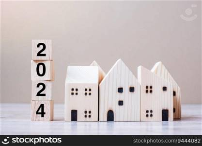 2024 Happy New Year with house model on table wooden background. Banking, real estate, investment, financial, savings and New Year Resolution concepts