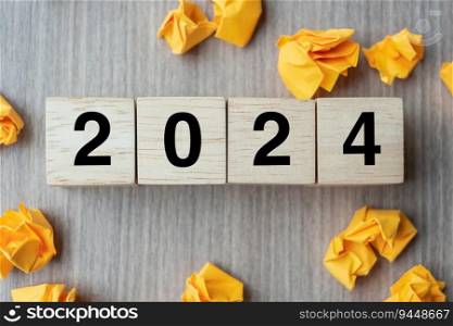 2024 text wood cube and crumbled paper  on wooden table background. New Year New Ideas, Creative, Innovation, Imagination, inspiration, Resolution, Strategy and goal concept
