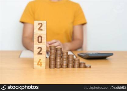 2024 year block with Coins stack. Money, Budget, tax, investment, financial, savings and New Year Resolution concepts