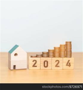2024 year block with house model and Coins stack. real estate, Home loan, tax, investment, mortgage, financial, savings and New Year Resolution concepts