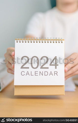 2024 Year Calendar on table with business woman using laptop computer. countdown, Happy New Year, Resolution, Goals, Plan,  Action, Mission and financial Concept