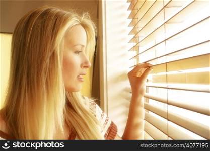 20s woman in her home looking out through her venison blinds. woman, looking, Venetian, blinds, certain, watching, portrait, sexy, bright, summer, spring, fresh, blond, emotion, expressive, 20s, a...