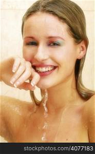 20s woman in shower with water flowing over her smiling face.