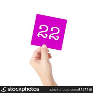 22 written on a card held by a hand