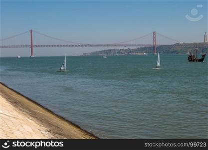 25th April Bridge in Lisbon over the Tagus River and Sailing Boats, Portugal