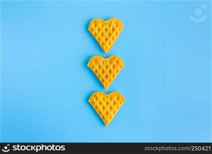 3 Pieces Heart Shape Waffle in Vertical on Blue Pastel Background Minimalist Style. Heart shape waffle dessert in minimalist style for food and dessert category