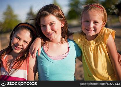3 smiling young girls hugging