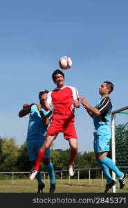 3 young men playing soccer