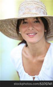 30 years old brunette wearing a straw hat and a summer dress