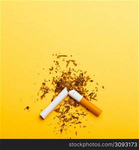 31 May of World No Tobacco Day, no smoking, close up of broken pile cigarette or tobacco STOP symbolic on yellow background with copy space, and Warning lung health concept