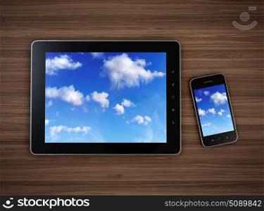 3d illustration of modern mobile devices on wooden table with cloudy sky on screen. Cloud computing concept.