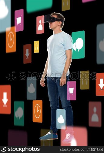 3d technology, gaming, augmented reality, cyberspace and people concept - happy young man in virtual reality headset or 3d glasses with menu icons over black background