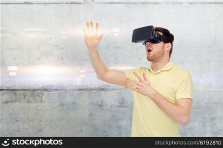 3d technology, virtual reality, entertainment and people concept - happy young man with virtual reality headset or 3d glasses playing game over gray concrete wall background