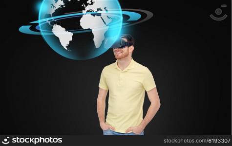 3d technology, virtual reality, entertainment and people concept - happy young man in virtual reality headset or 3d glasses with earth or planet hologram over black background