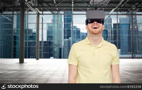 3d technology, virtual reality, entertainment and people concept - happy young man with virtual reality headset or 3d glasses playing game over industrial empty room and city panorama background