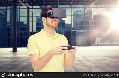 3d technology, virtual reality, entertainment and people concept - happy young man with virtual reality headset or 3d glasses playing with game controller gamepad over empty industrial room . happy man in virtual reality headset with gamepad
