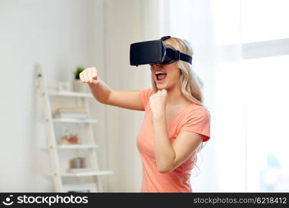 3d technology, virtual reality, entertainment and people concept - happy young woman with virtual reality headset or 3d glasses playing game and fighting at home