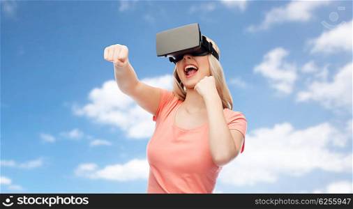 3d technology, virtual reality, entertainment and people concept - happy young woman with virtual reality headset or 3d glasses playing game and fighting over blue sky and clouds background