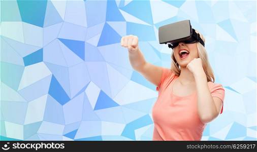 3d technology, virtual reality, entertainment and people concept - happy young woman with virtual reality headset or 3d glasses playing game and fighting blue low poly texture background
