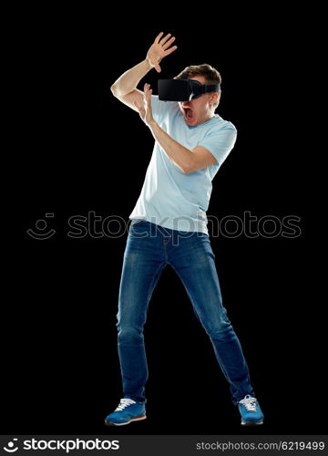 3d technology, virtual reality, entertainment and people concept - scared young man with virtual reality headset or 3d glasses playing game, hiding from something and screaming