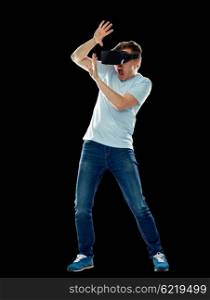 3d technology, virtual reality, entertainment and people concept - scared young man with virtual reality headset or 3d glasses playing game, hiding from something and screaming