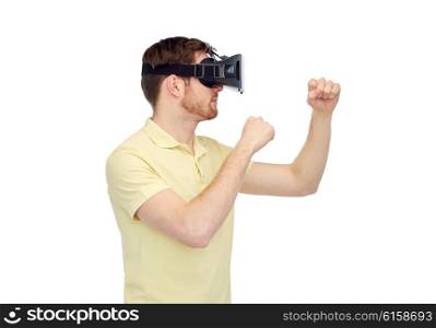 3d technology, virtual reality, entertainment and people concept - young man with virtual reality headset or 3d glasses playing game and fighting