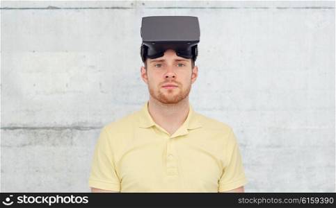 3d technology, virtual reality, entertainment and people concept - young man with virtual reality headset or 3d glasses over concrete gray wall background