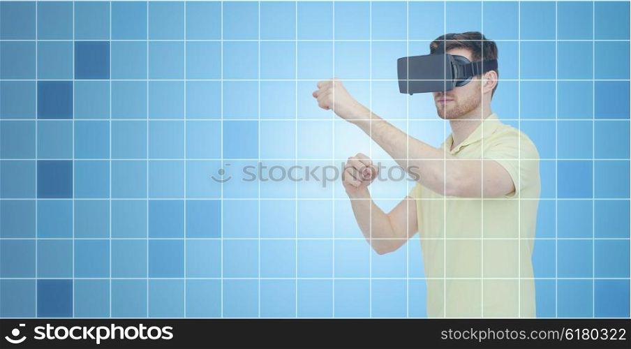 3d technology, virtual reality, entertainment and people concept - young man with virtual reality headset or 3d glasses playing game and fighting over blue grid background