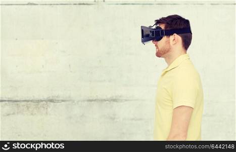 3d technology, virtual reality, entertainment and people concept - young man with virtual reality headset or 3d glasses over concrete gray wall background. man in virtual reality headset or 3d glasses