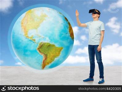 3d technology, virtual reality, entertainment, cyberspace and people concept - happy man with virtual reality headset or 3d glasses playing game and touching earth globe over sky and clouds background