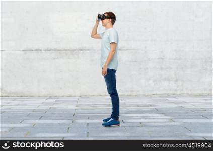 3d technology, virtual reality, entertainment, cyberspace and people concept - happy young man with virtual reality headset or 3d glasses over street background