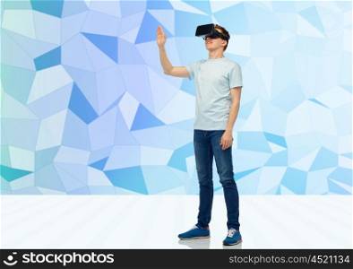 3d technology, virtual reality, entertainment, cyberspace and people concept - happy young man with virtual reality headset or 3d glasses playing game and touching something over low poly background