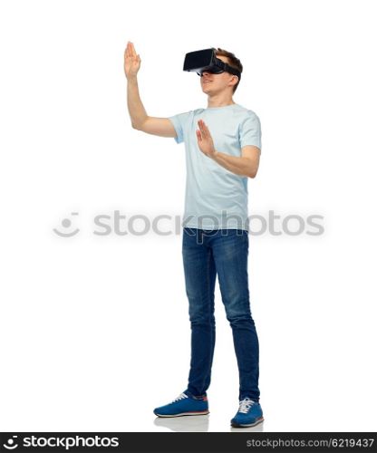 3d technology, virtual reality, entertainment, cyberspace and people concept - happy young man with virtual reality headset or 3d glasses playing game and touching something