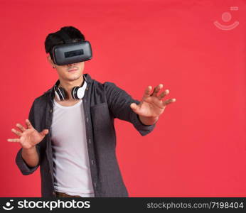 3d technology, virtual reality, entertainment, cyberspace and people concept - happy young caucasian handsome man with virtual reality headset or 3d glasses playing game and catching something